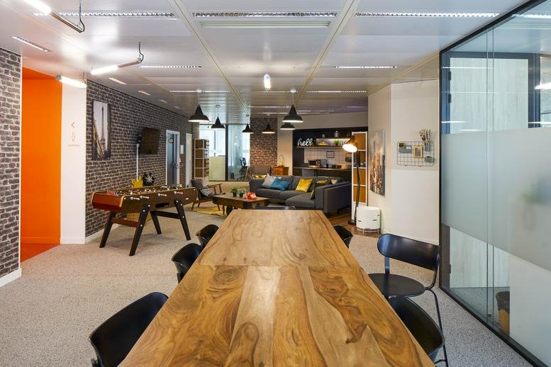 Spacious communal lounge at 110, Esplanade du Général de Gaulle, Courbevoie, featuring a foosball table and wooden table.