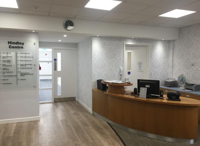 Professional reception area with a curved wooden desk and wall directory.
