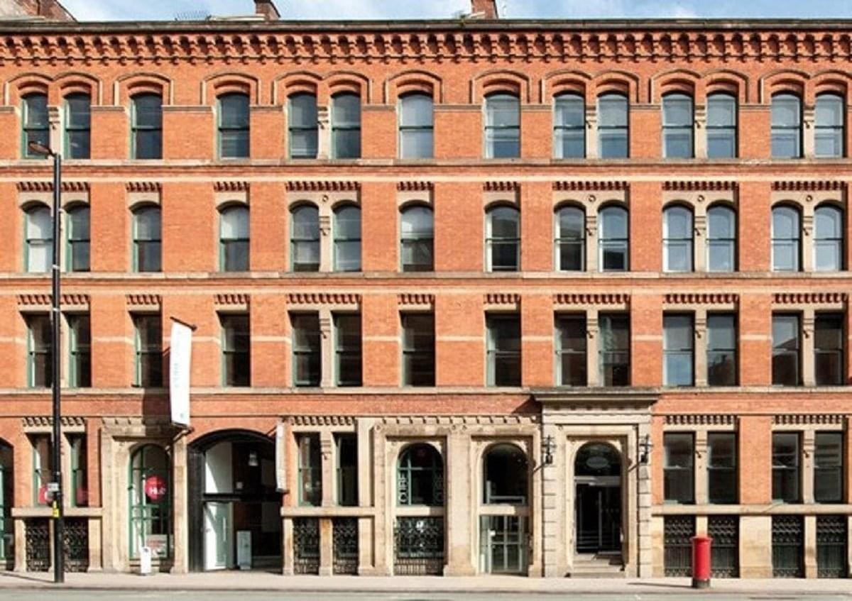 The classic red brick exterior facade of 113/115 Portland Street, Manchester.