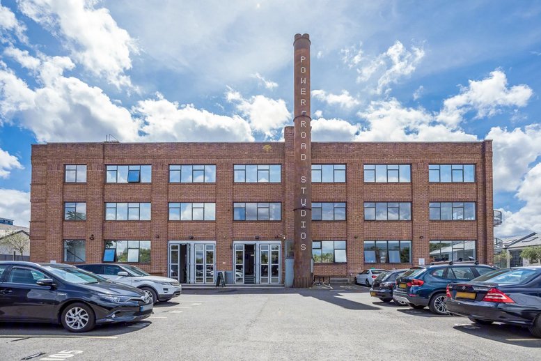 Exterior brick facade of Power Road Studios, 114 Power Road, Chiswick, London, featuring a tall branded chimney.