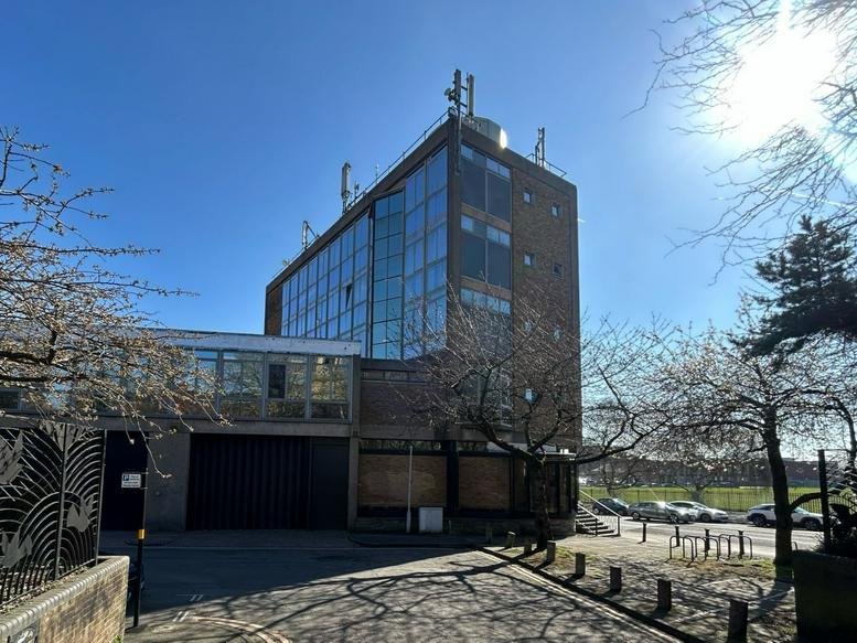 Exterior view of the brick and glass facade of GN House on a sunny day.