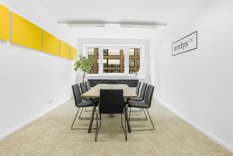 Meeting room at andys Wohllebengasse, 12-14 Wohllebengasse, featuring a wooden table and yellow acoustic wall panels.