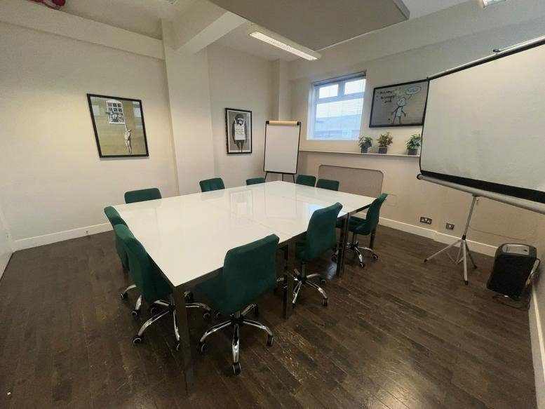 Spacious boardroom with a large white table and green velvet chairs at 12 Deer Park Road.