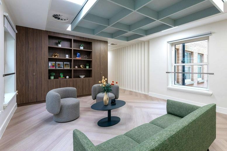 Modern lounge at 123, Pall Mall, London with wood-paneled shelving and a distinctive teal coffered ceiling.