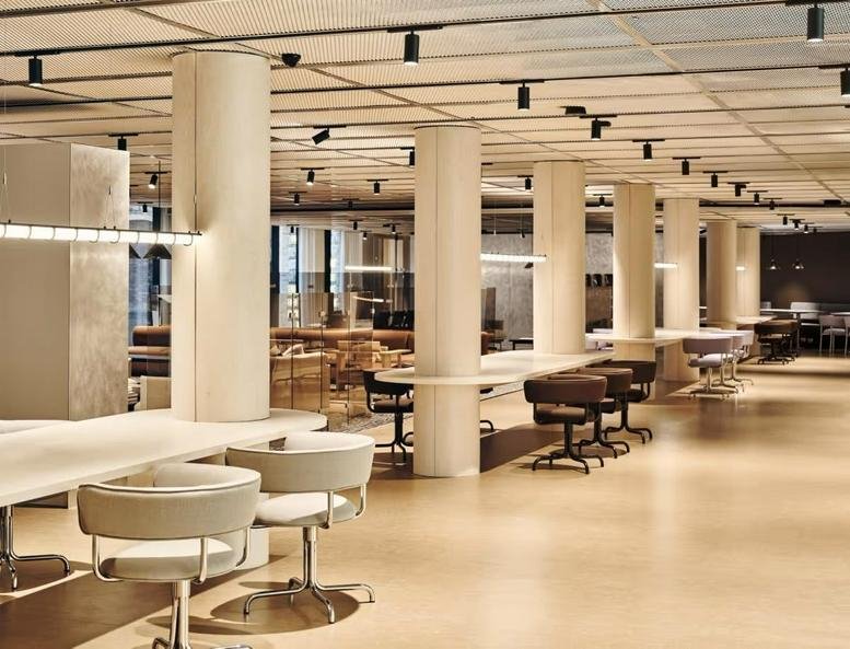 Open-plan coworking area with circular columns and designer task seating.
