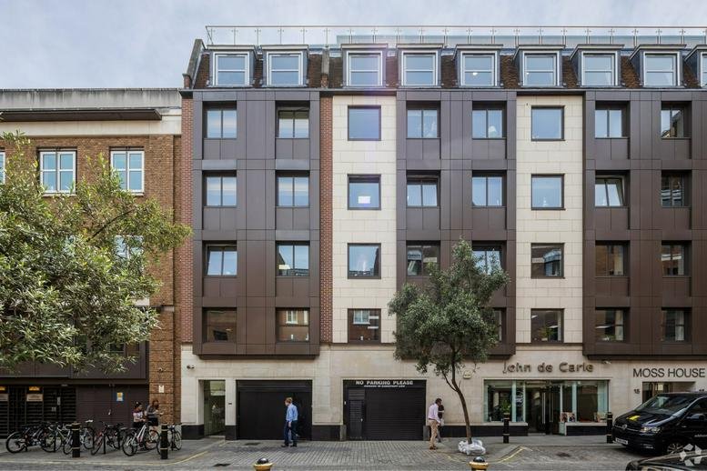 The modern exterior facade of 15-16 Brook's Mews in Mayfair, featuring dark bronze-colored paneling.