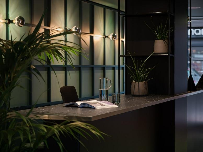 Bar-style workspace at 151 Wardour Street with lush indoor plants and warm mood lighting.