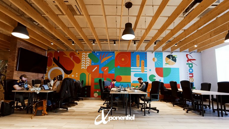 Open-plan workspace with timber ceiling slats and vibrant wall art.