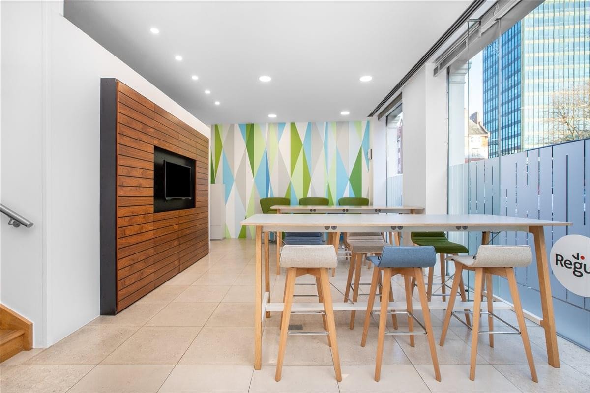 Vibrant communal dining space with a wood-paneled feature wall and colorful mural.