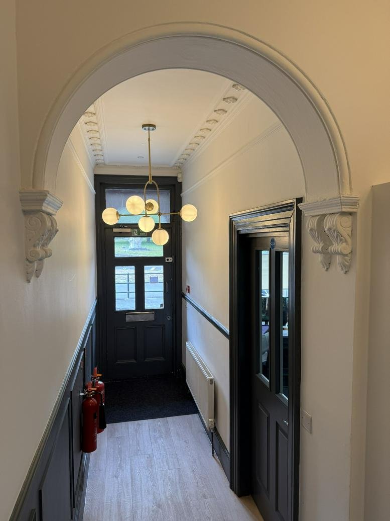 Elegant entrance hallway at 17 College Place featuring a decorative archway and globe chandelier.