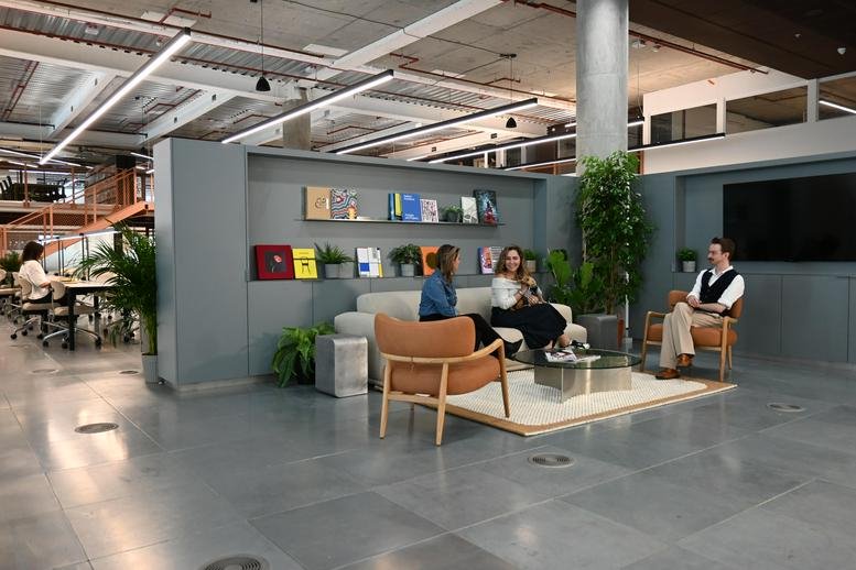 Modern lounge area at MediaWorks, 191 Wood Lane, White City, London with a large display screen.
