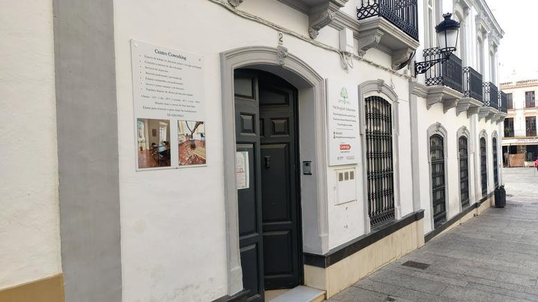 Street-level view of the historic building exterior with traditional black iron balconies.