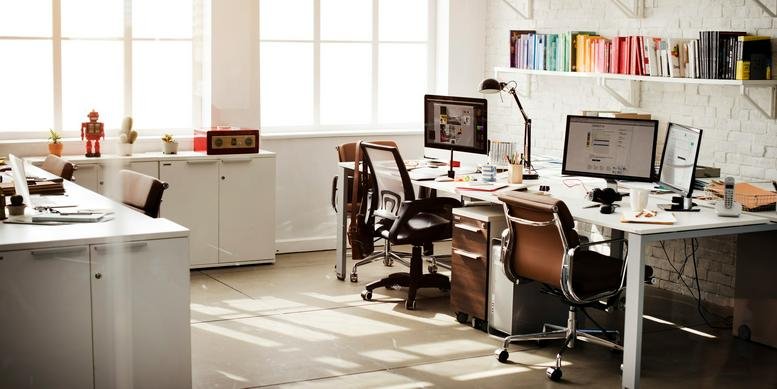 Spacious creative office at 2, Cours du XXX Juillet with natural light, colorful bookshelves, and multiple workstations.