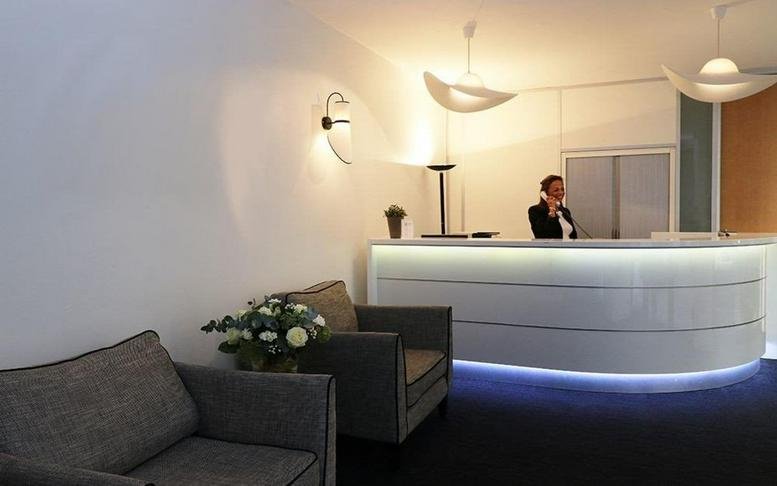 Bright reception area with curved white desk at 20, Rue Cambon, Paris, Paris Ile de France.