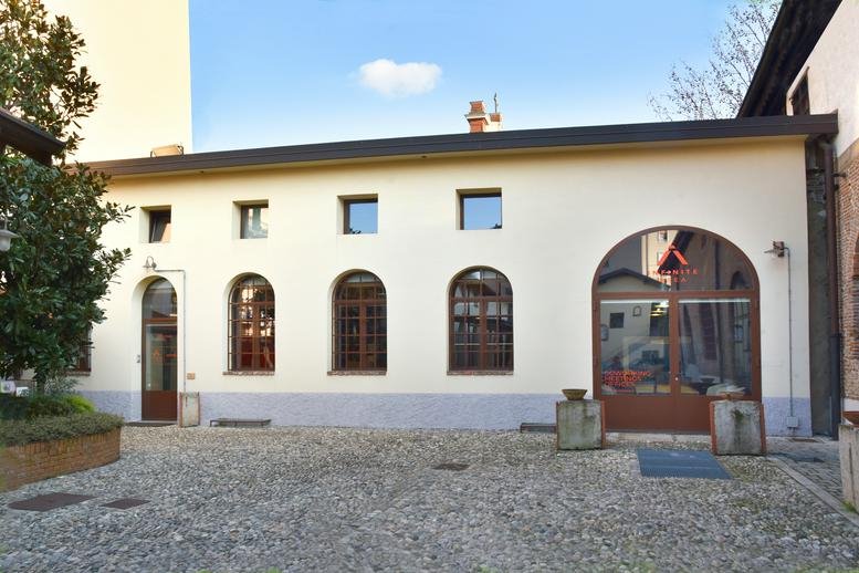 Exterior view of the historic cream-colored facade of Infinite Area Milano with arched windows.