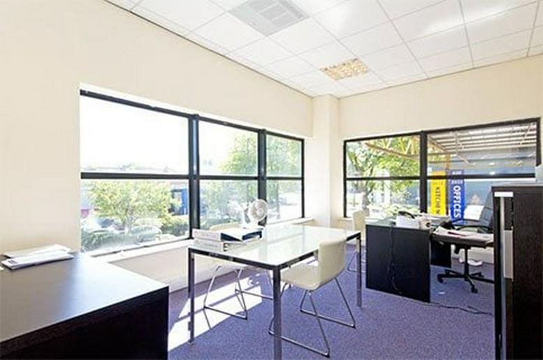 Bright, naturally lit private office at 214 Acton Lane featuring white desks and large windows.