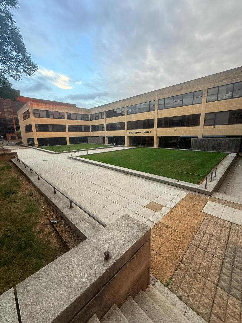 Exterior view of the office building at 214 Upper Fifth Street, Central Milton Keynes, showing a lawn and courtyard.