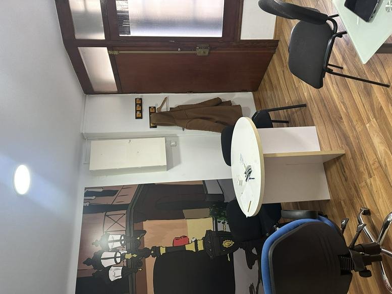 Workspace area with a round white table, blue seating, and wood-paneled accents.