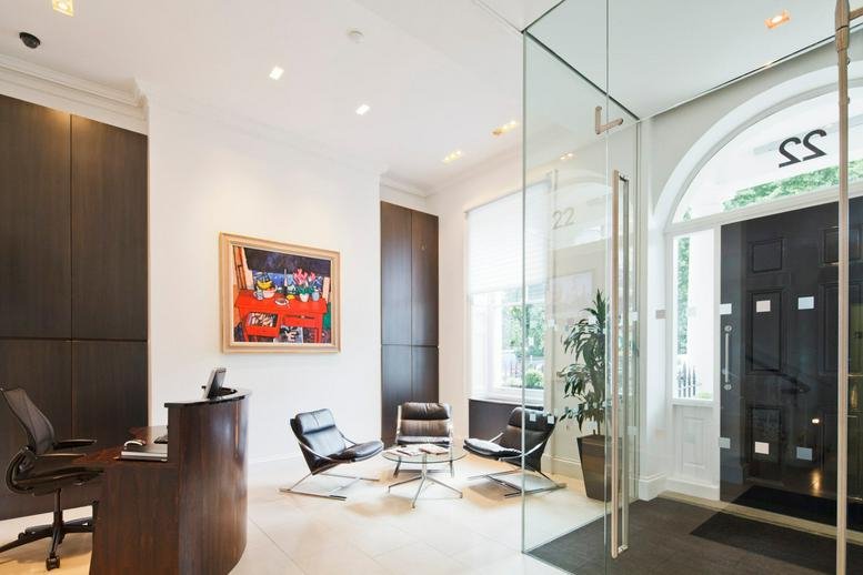 Bright, modern reception lobby with mid-century modern chairs, glass partitions, and abstract art.