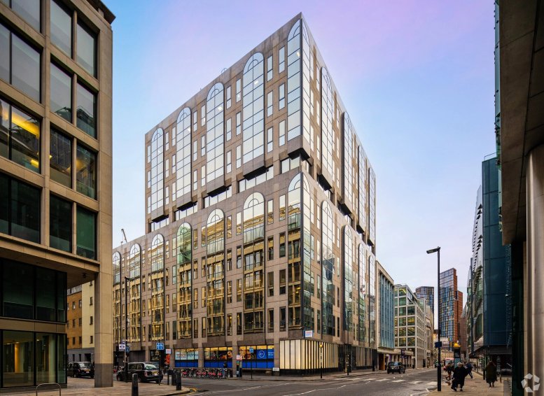 Angular view of the modern stone and glass exterior of Industrious Chiswell Street in London.