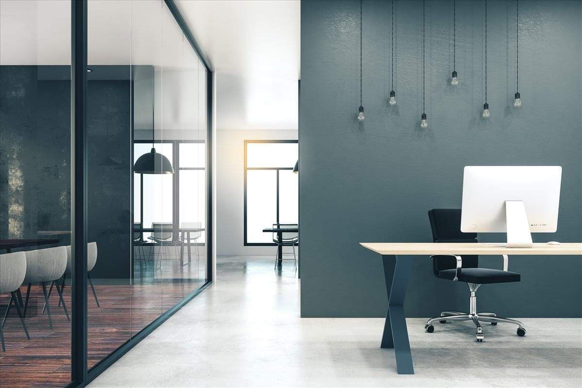 Modern workspace at 249-251 Merton Road with a wooden desk and teal feature wall.