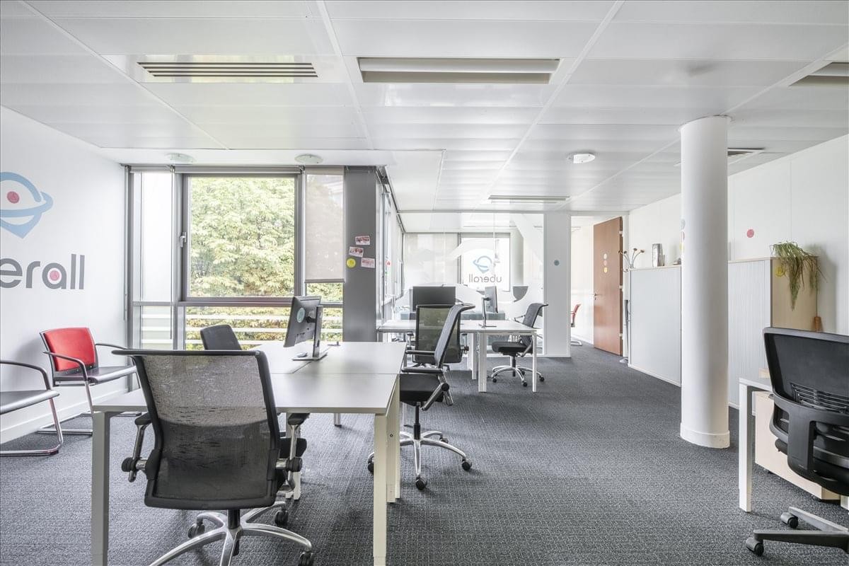 Spacious open-plan office at 26-28 Rue de Londres featuring multiple desks and natural light.