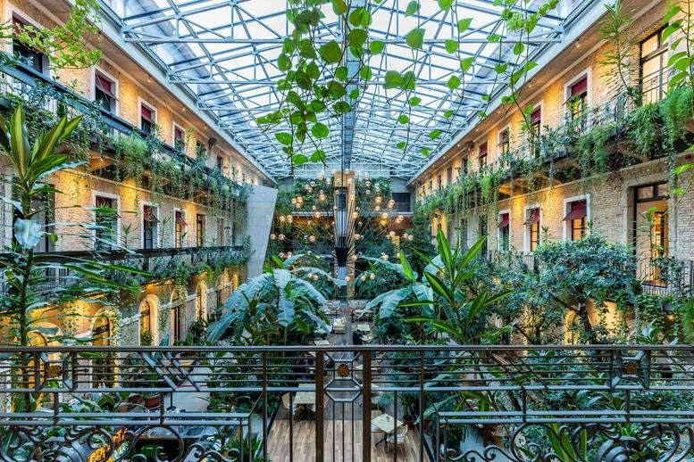 Spacious sunlit courtyard atrium with lush greenery at Create. 26, 26 Király Street, Pest, Budapest, Hungary.