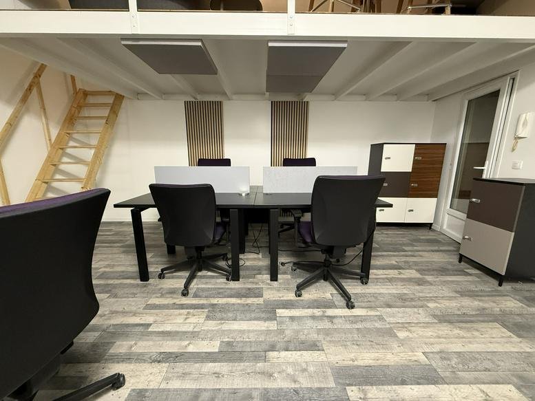Spacious open-plan workspace at 26 Rue Carnot with sleek black desks and mezzanine level.