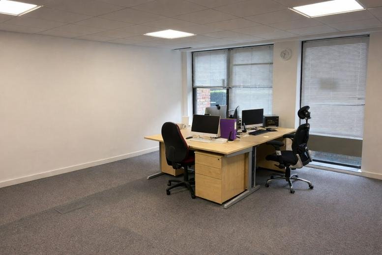 Spacious office suite at 27-43 Eastern Road featuring a central desk pod and natural light from large windows.