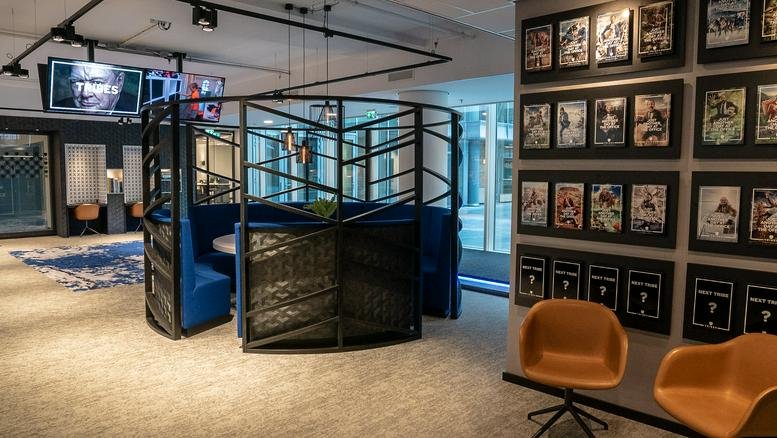 Spacious communal lounge at South Axis ITO Tower featuring blue semi-private booths and wall-mounted art.