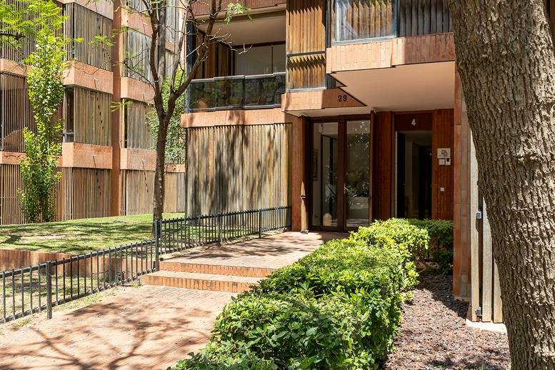 Exterior entrance and facade of Raset29 with landscaped pathway and trees.