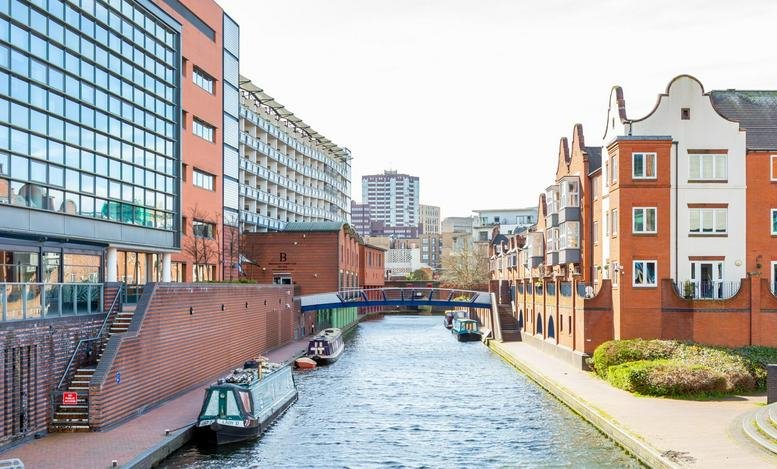 Exterior view of the red brick and glass buildings at 3 Brindley Place overlooking the canal.