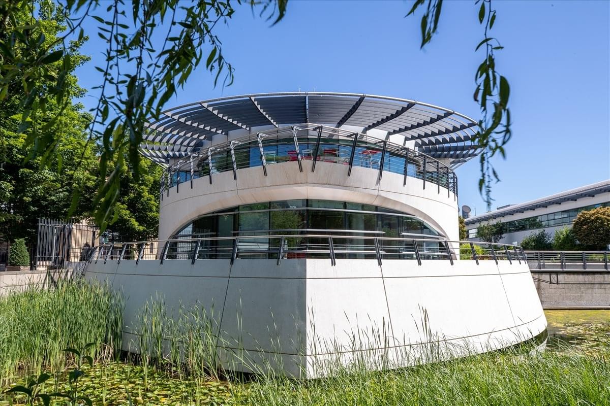 Exterior view of the unique circular building at 3 Place Giovanni Verrazzano with solar panels.