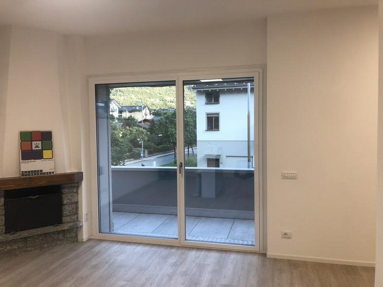 Spacious office room with a stone fireplace and large sliding glass doors leading to a terrace.