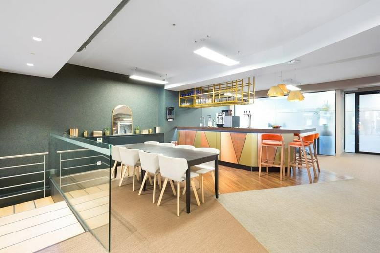 Spacious communal lounge and dining area at 30 Newman Street with bar seating and natural light.