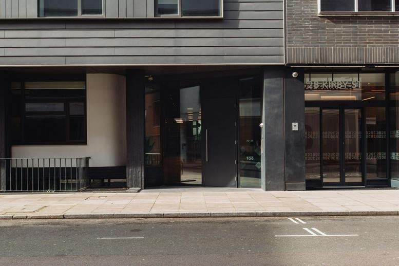 Street level entrance and exterior view of the modern brick facade at 31, 35 Kirby Street, Central London.