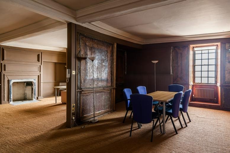 Spacious meeting room at The Merchant's House, 339-343 High Street with dark wood paneling and a blue chair set.