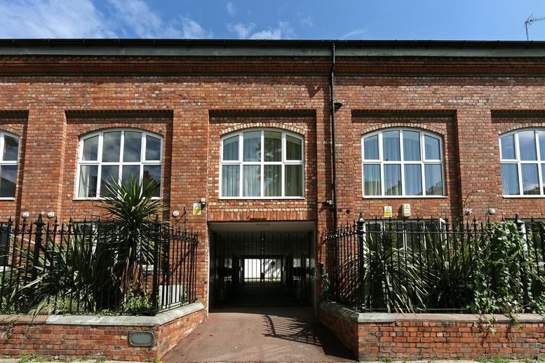 Exterior brick facade of 36 Gloucester Avenue with arched windows and iron fencing.