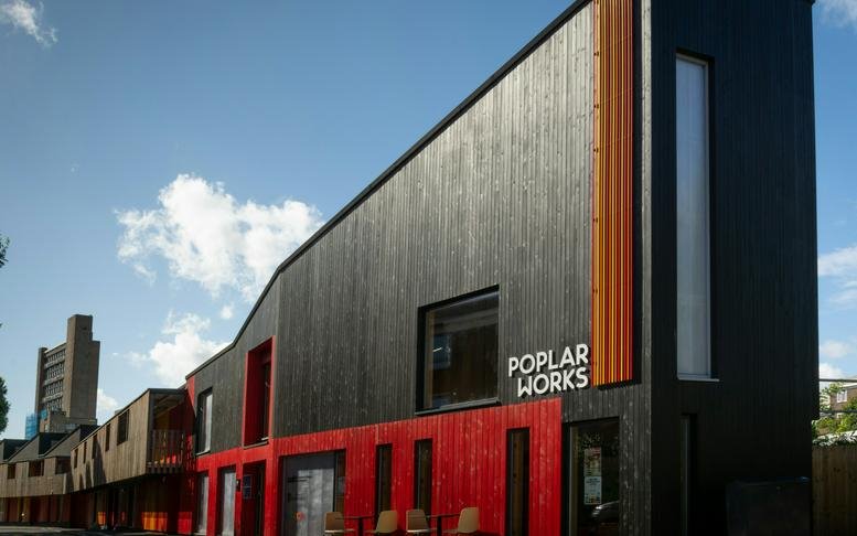 Modern workspace with a striking black and red wood-paneled exterior.