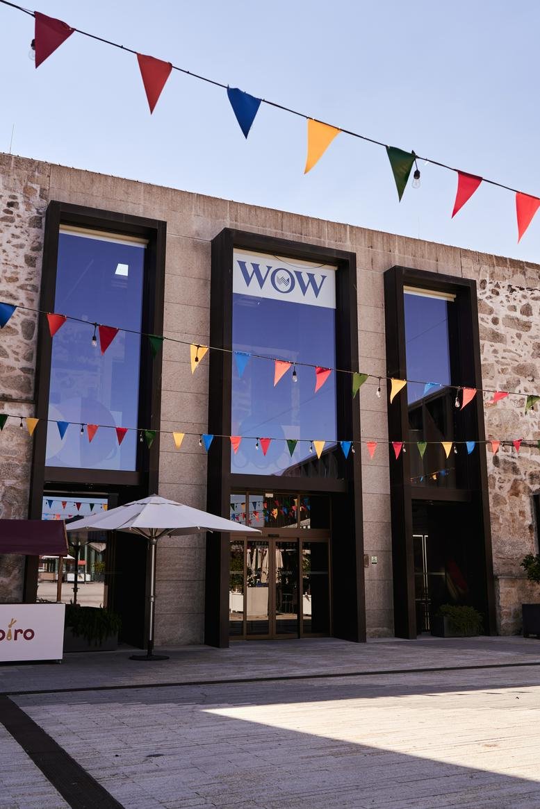 Stone exterior facade of the building at 39 Rua do Choupelo with colorful festive bunting.