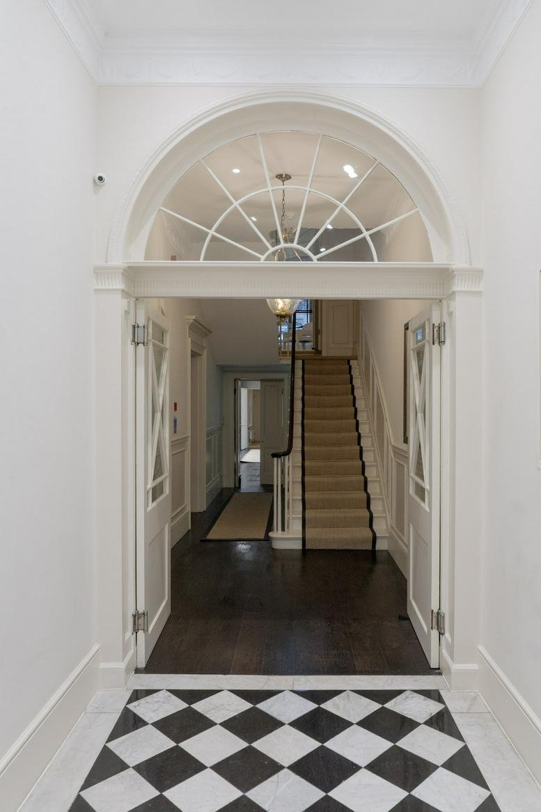 Grand arched entrance hallway at 4 Fitzhardinge Street with a checkered marble floor.