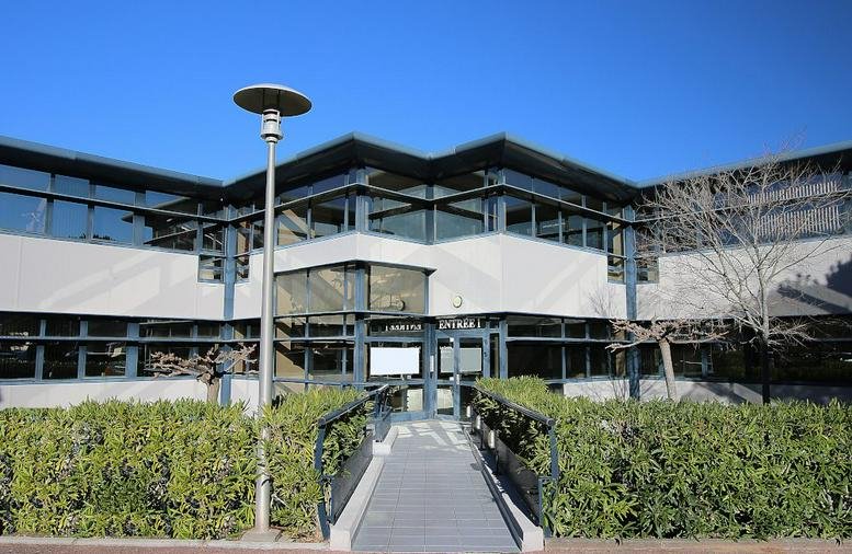 Exterior view of the low-rise office building with glass facade at 400, av Roumanille.