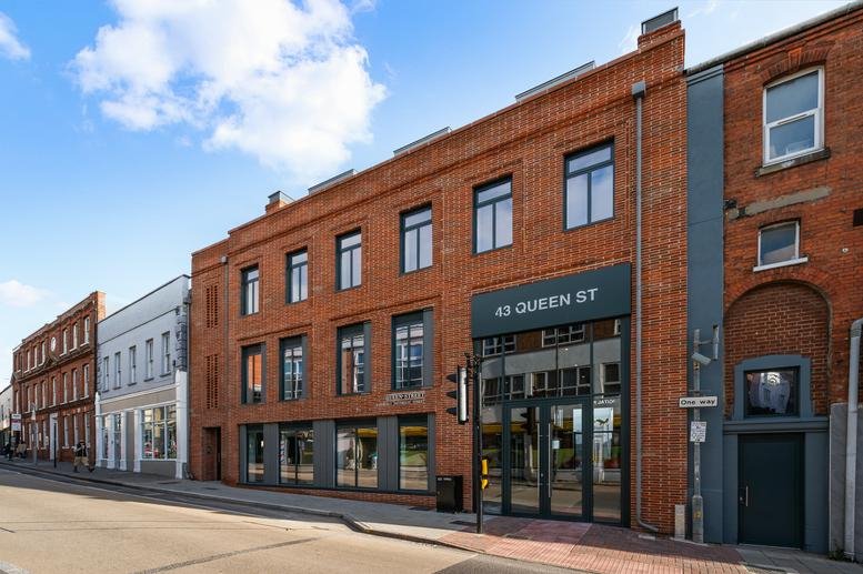 Exterior brick facade of The Digital Forum, 43 Queen Street with large glass entrance.