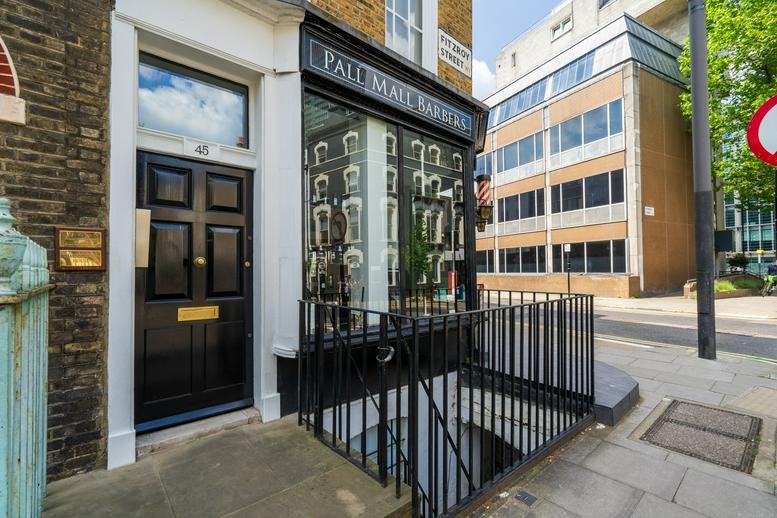 Exterior entrance at 45 Fitzroy Street with a black front door and large display window.