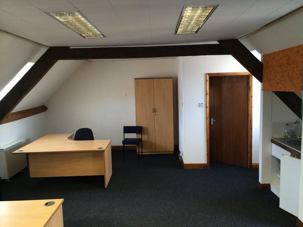 Spacious office suite at 46 Market Square, Witney, Oxfordshire with wooden beams and a corner desk.