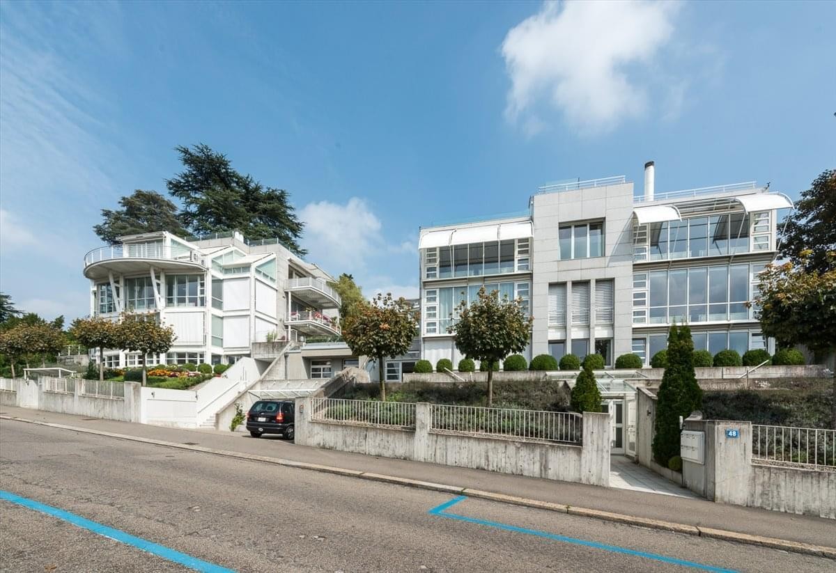 Exterior view of the contemporary white multi-story building at 48-50 Sonnenbergstrasse, Zurich.