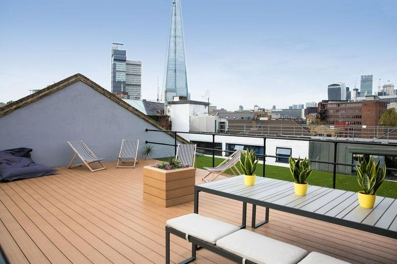 Spacious rooftop terrace at 5-7 Tanner Street, Bermondsey, with wooden decking and views of The Shard.