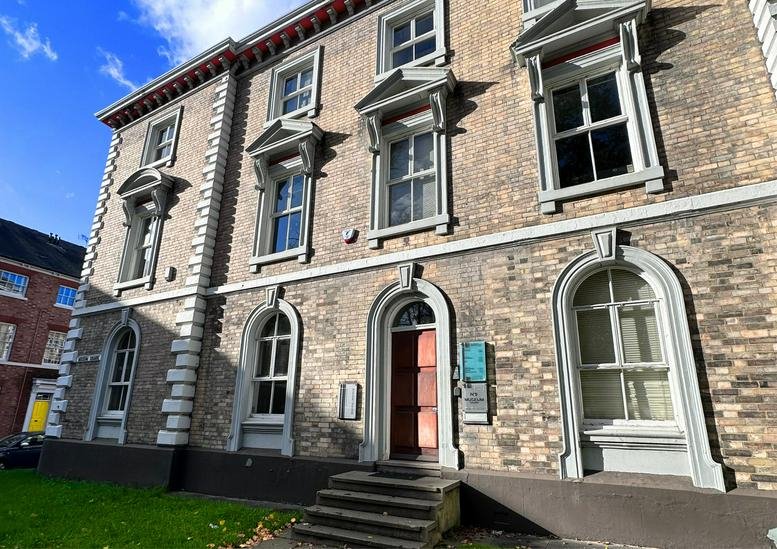Exterior view of the historic brick facade and arched entrance at 5 Museum Square.