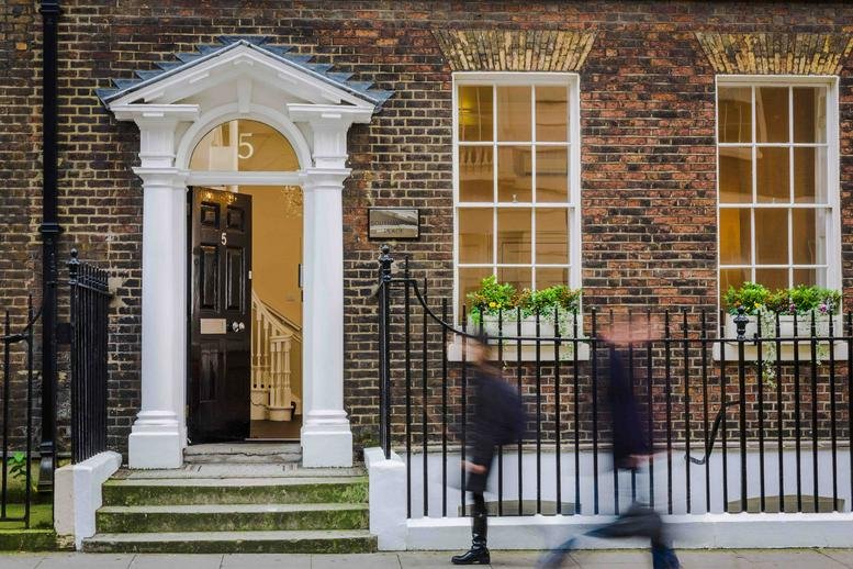 Brick exterior of 5 Southampton Place with a white arched doorway and black iron railings.