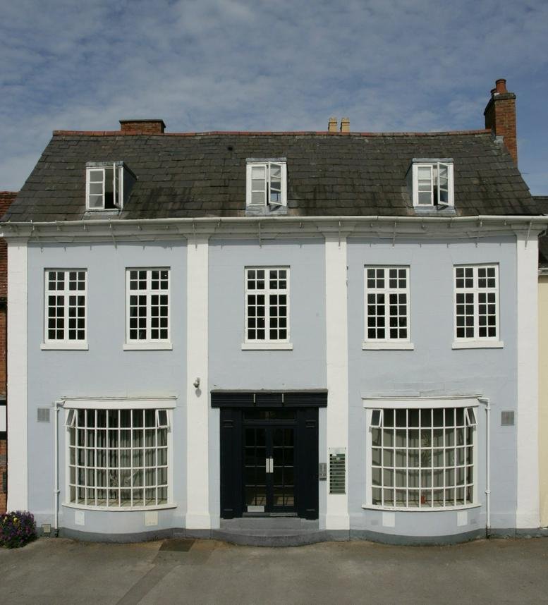 Exterior of the light blue Georgian-style building at 50 High Street, Henley in Arden.